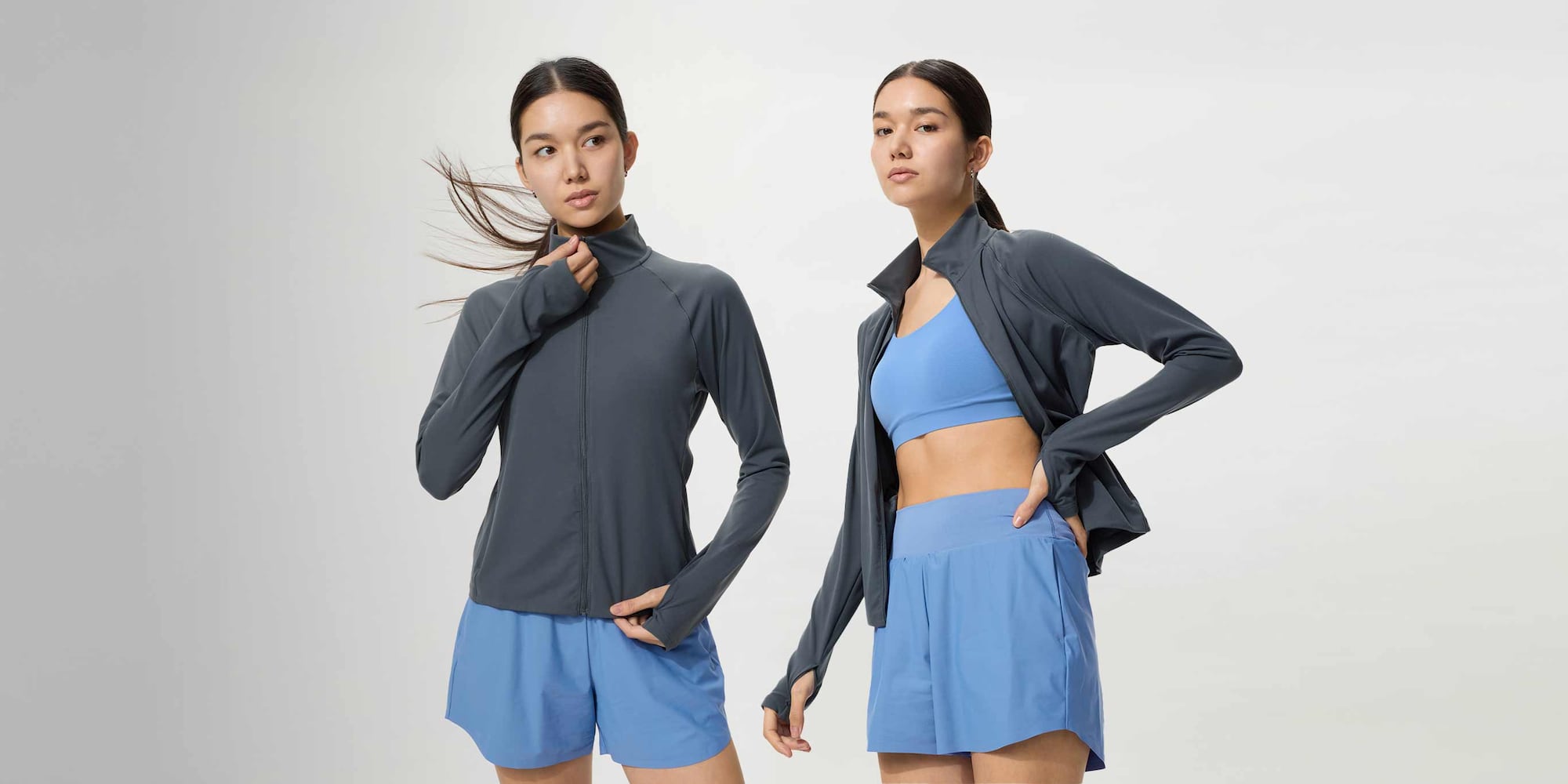 model wearing Ultra Stretch Active Full-Zip Jacket in dark grey over a light blue sports bra and shorts set