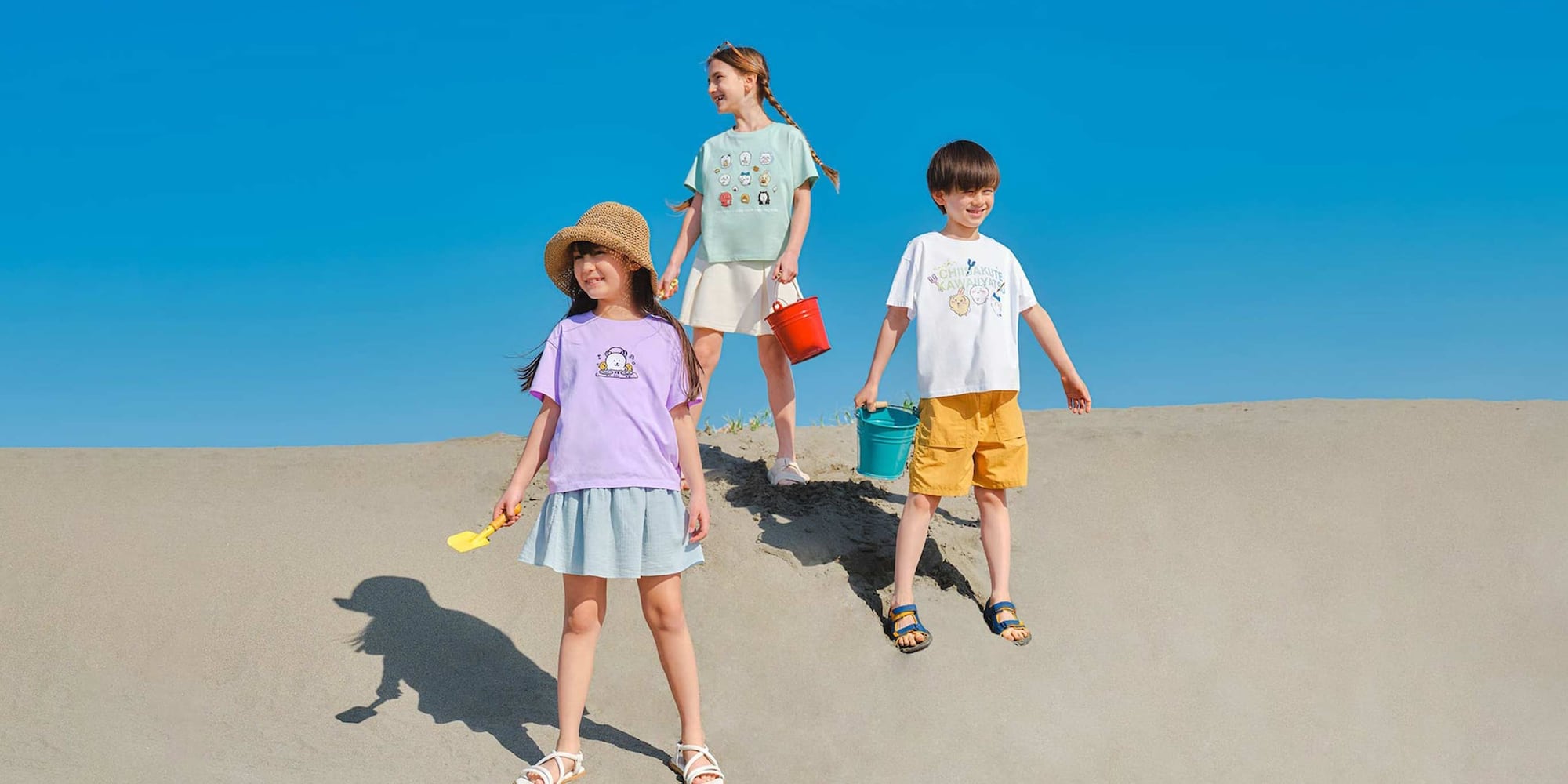 models on the beach wearing CHIIKAWA x JOKE BEAR AND FRIENDS UT Graphic T-Shirts