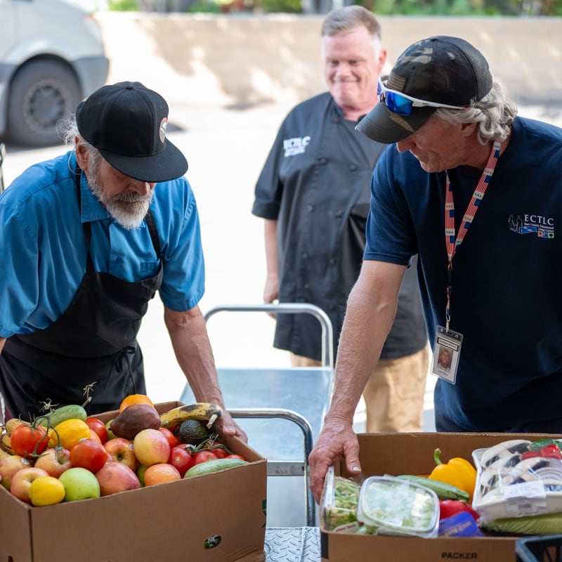 Two men picking up boxes of food