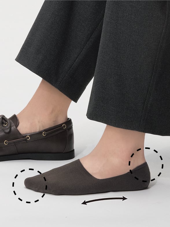 close up of feet wearing a pair of uniqlo socks in brown, one without a shoe, one wearing a brown loafer