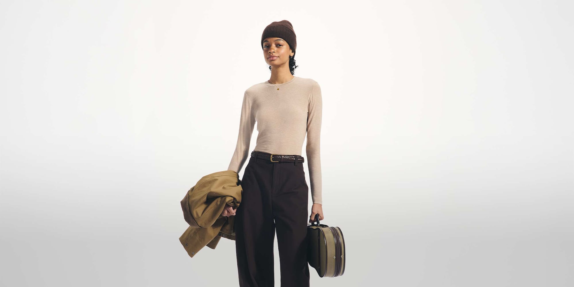 model wearing HEATTECH Extra Warm Cashmere Blend Crew Neck T-Shirt in beige with brown trousers, belt and beanie