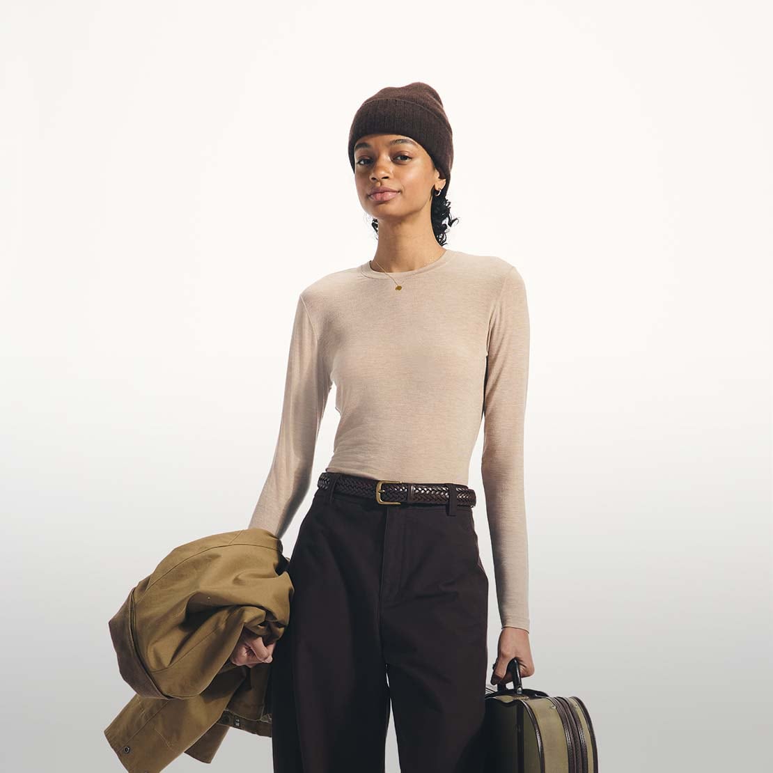 model wearing HEATTECH Extra Warm Cashmere Blend Crew Neck T-Shirt in beige with brown trousers, belt and beanie