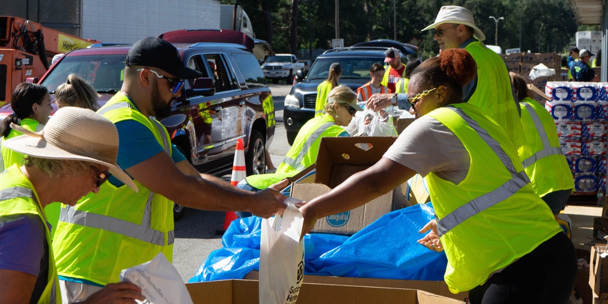 People giving out food to other people