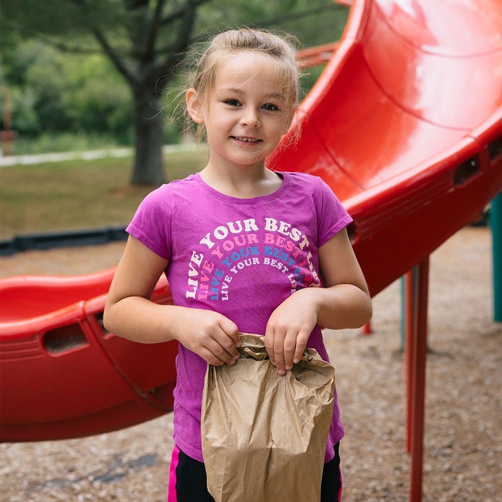 Girl smiling and holding a bag of food