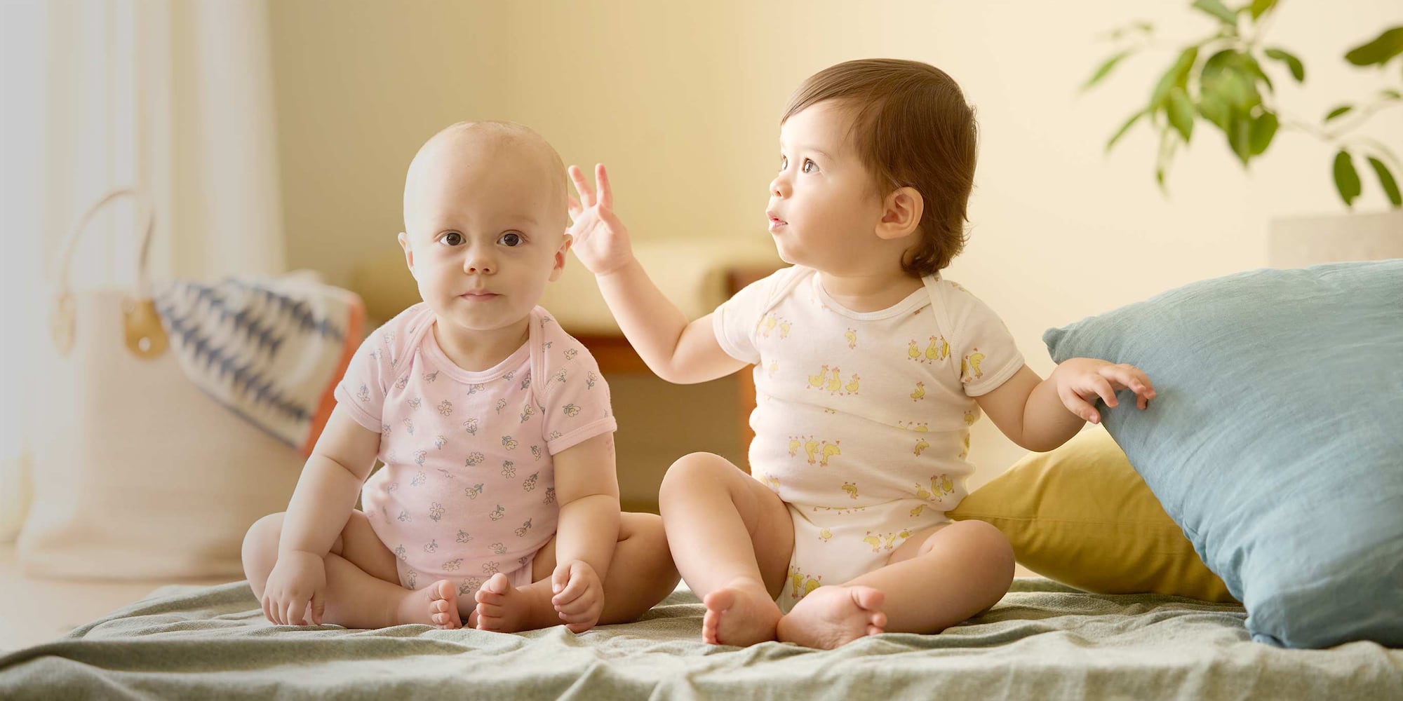 two models wearing bodysuits in pink pointelle and yellow animal print designs